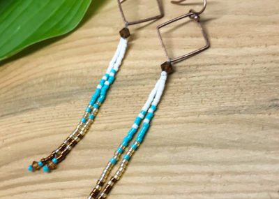 Aztec Sea Ombre Fringe Drop Earrings on wood background.